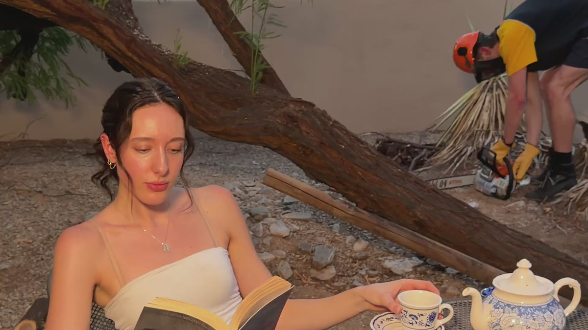 Load video: Woman reading calmly while a chainsaw runs nearby