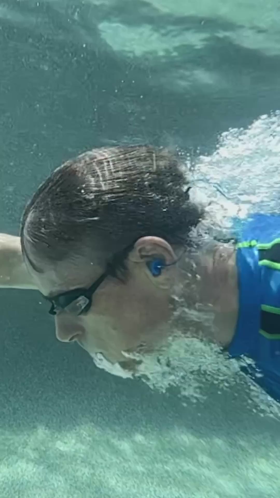 Load video: Swimmer underwater wearing Fluid earplugs