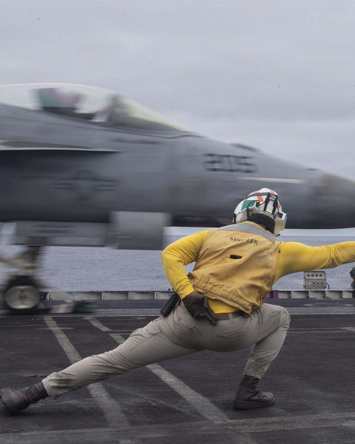 Flight-deck shooter signals an F/A-18 launch — U.S. Navy photo by Seaman Apprentice Cesar Zavala